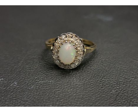 OPAL AND DIAMOND CLUSTER RINGthe central oval cabochon opal approximately 0.75cts in sixteen diamond surround, on nine carat 