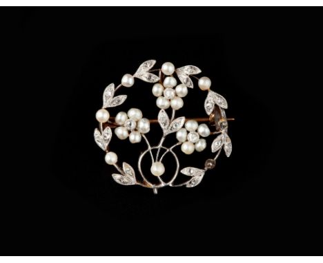 A DIAMOND AND PEARL PANEL BROOCH/PENDANT, the circular openwork panel designed as a foliate wreath enclosing a spray of flowe