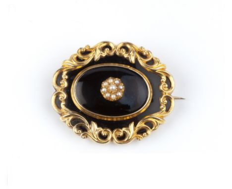 A VICTORIAN MEMORIAL BROOCH, the shaped oval panel centred with a half pearl cluster to a black ground, framed by foliate scr