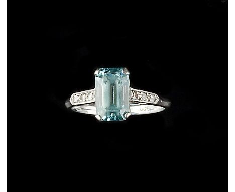 A BLUE ZIRCON AND DIAMOND DRESS RING, the rectangular step-cut blue zircon with canted corners, claw set between raised mille