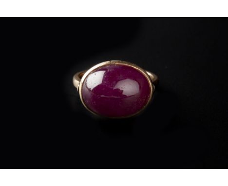 A RUBY SINGLE STONE RING, the oval cabochon ruby in collet setting, yellow precious metal mounted, stamped '18k', ring size a