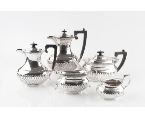 A LATE VICTORIAN SILVER THREE PIECE TEA SERVICE, with gadrooned borders and half lobed decoration, the teapot with ebonised h