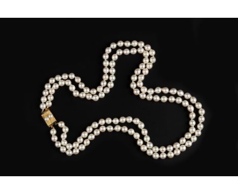 A DOUBLE STRAND CULTURED PEARL NECKLACE, comprising two strands of slightly graduated cultured pearls, to a textured panel cl