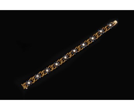 A SAPPHIRE AND DIAMOND SET BRACELET BY KUTCHINSKY, designed as a series of abstract entwined hoop links, spaced by flowerhead