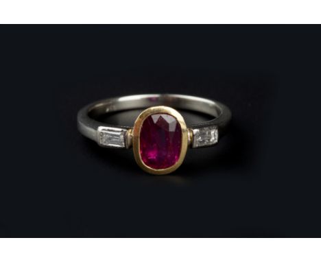 A RUBY AND DIAMOND THREE STONE RING, the oval mixed-cut ruby collet set between two baguette-cut diamonds, two colour preciou