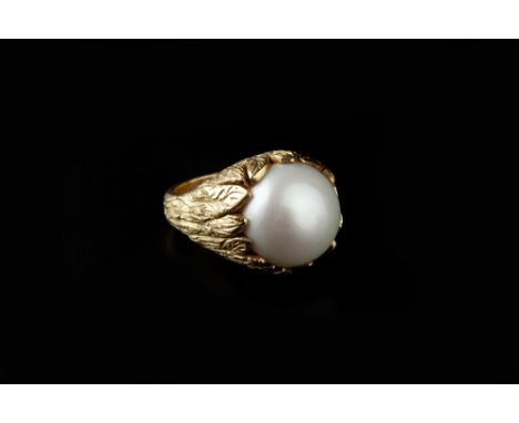 A MABE PEARL DRESS RING, the stylised foliate mount with engraved textured decoration, 18ct gold mounted, maker's mark 'AJW',