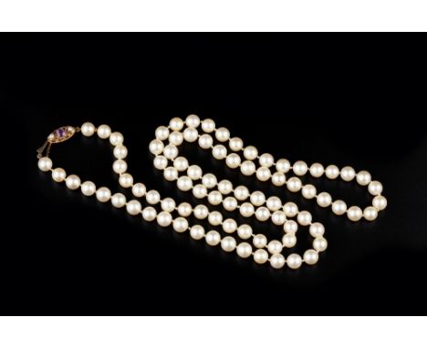 A SINGLE STRAND CULTURED PEARL NECKLACE, with a 9ct gold oval openwork clasp, centred with a circular mixed-cut amethyst and 