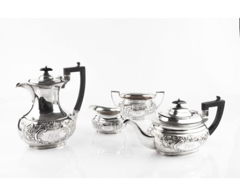 AN EDWARDIAN SILVER FOUR PIECE TEA SERVICE, repoussé decorated with flowers and scrolling foliage, the teapot and hot water p
