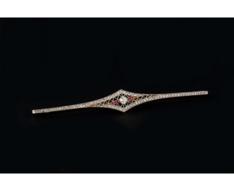 AN EARLY 20TH CENTURY DIAMOND AND GEM SET BAR BROOCH, the tapered bar centred with a millegrain set old brilliant-cut diamond