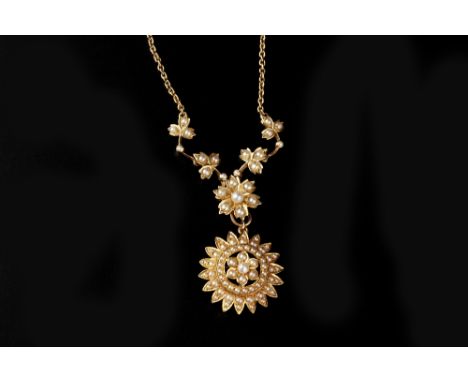 AN EDWARDIAN HALF PEARL PENDANT NECKLACE, the trace-link necklace centred with a half pearl set flowerhead and undulating fol