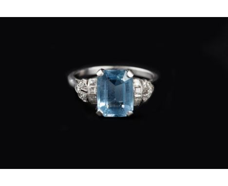 AN ART DECO AQUAMARINE AND DIAMOND DRESS RING, the rectangular step-cut aquamarine in four claw setting, bordered by collars 