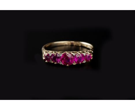 A SYNTHETIC RUBY FIVE STONE RING, the graduated circular mixed-cut synthetic rubies to a scroll pierced mount, stamped '18c',