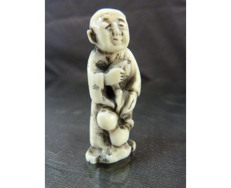 JAPANESE IVORY NETSUKE. Carved and worked ivory pendant typically worn on a kimono of an aged Japanese working man. 