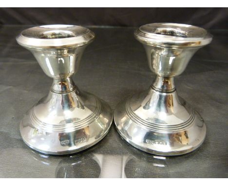 Pair of hallmarked silver candlestick London 1914 and 1912. Denting to top of one and wooden bases. 