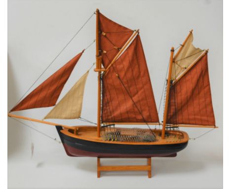 A scale model of a two-masted boat on stand