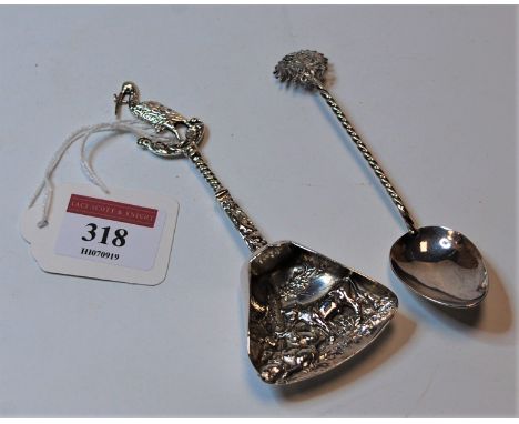 A circa 1900 continental white metal caddy scoop, the triangular bowl relief decorated with cattle, the stem surmounted by a 