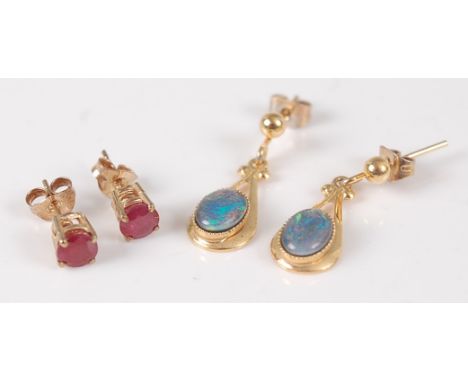 A pair of yellow metal and cabochon opal set ear pendants; together with a pair of 9ct gold and round cut ruby set ear studs 