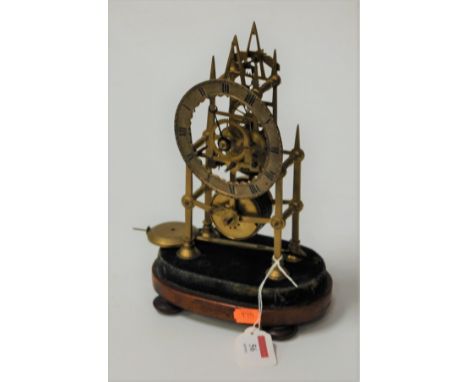 A late Victorian brass skeleton clock, having chain driven fusee movement, raised on walnut plinth (dial loose and lacking gl