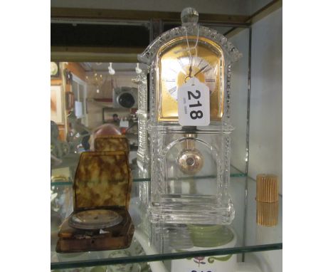 A glass clock and two travelling clocks