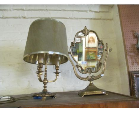 A brass dressing table mirror and a lamp