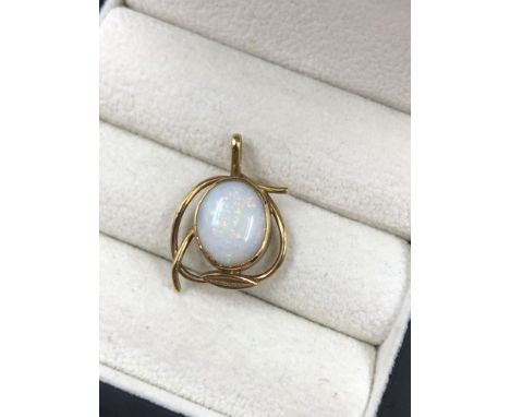 A VINTAGE OVAL OPAL PENDANT IN AN RUB OVER AND STYLISED SETTING. THE BAIL STAMPED 9ct EH. ASSESSED AS 9ct GOLD. WEIGHT 2.12gr