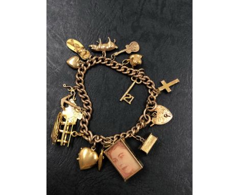 A VINTAGE 9ct GOLD CHARM BRACELET WITH A VARIETY OF 9ct AND 18ct ATTACHED CHARMS. GROSS WEIGHT 42.02grms. the proceeds from t
