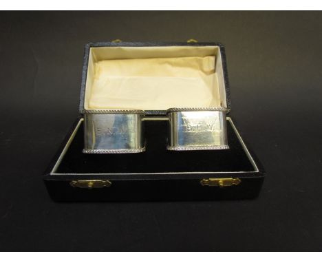 A pair of William Hair Haseler cased silver napkin rings, monogrammed, Birmingham 1909, 69g