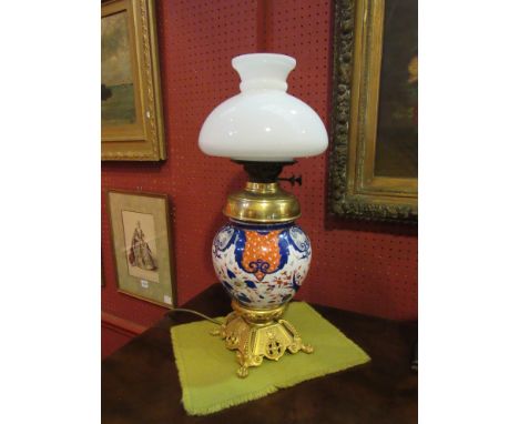 An Edwardian table lamp with ornate ormolu base and Imari ceramic body, opaque white shade 