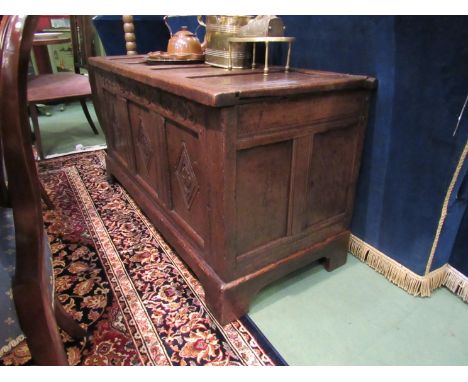 A 17th Century and later oak panelled coffer, hinged lid over a carved lozenge front on bracket feet