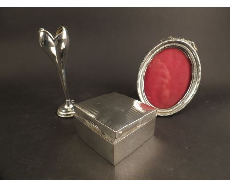 An oval framed silver photograph frame stamped Birmingham an E.P.N.S bud vase and a Silver cigarette box of square form with 