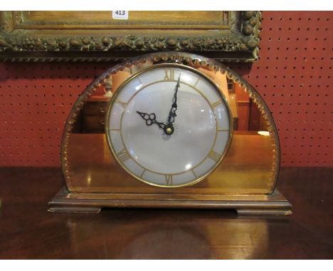 An Art Deco mantel clock with copper colour mirrored back, Roman numerated chapter ring 
