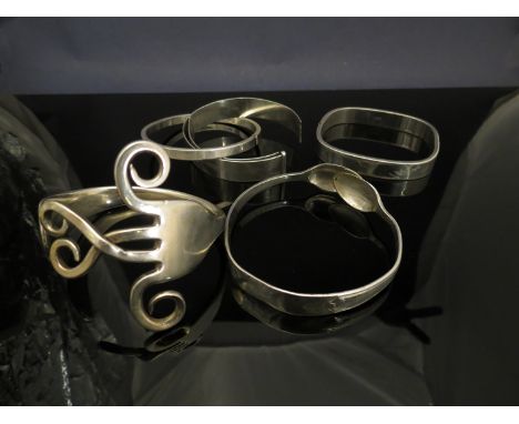 A silver fork fashioned into a bracelet a similar EPNS example and three further silver bracelets (5) 