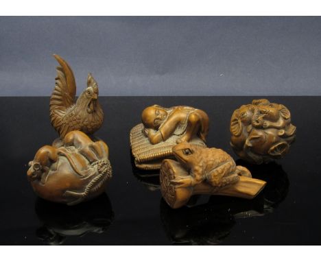 Four netsuke including a sleeping buddha and a puzzle ball 