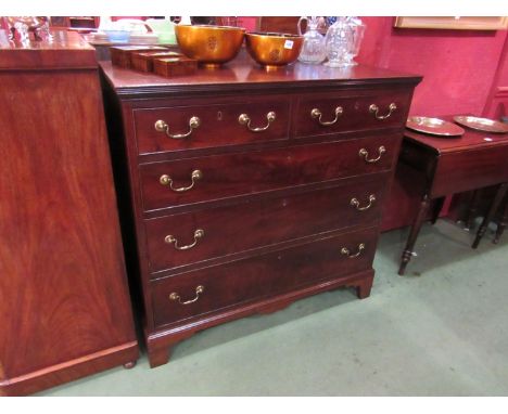 A George III mahogany chest of two short over three graduating long drawers with brass swan neck handles over bracket feet 