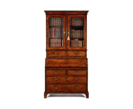 A GEORGE I WALNUT AND FEATHERBANDED SECRETAIRE BOOKCASE CIRCA 1725The fall front drawer opening to an arrangement of pigeon h