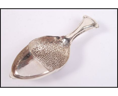 A sterling silver caddy spoon in the form of an acorn, weighs 12 grams.