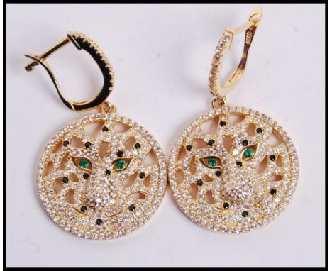 A pair of Cartier style silver gilt earrings in the form of tigers with CZ stones and green stone eyes, weighs 10..2 grams.