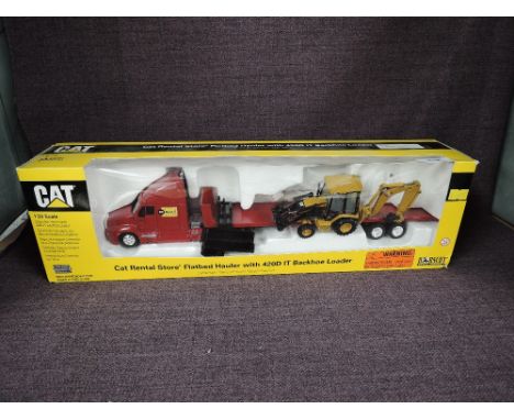 A Norscot 1:50 scale diecast, CAT Rental Store Flatbed Hauler with 420D IT Backhoe Loader, in original polystyrene packaging 