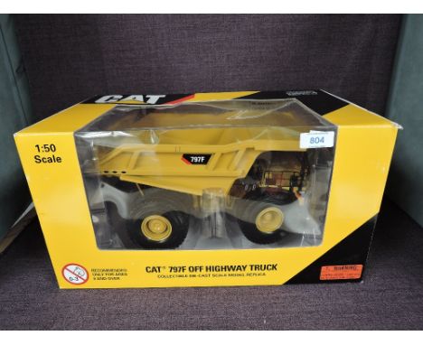 A Norscot 1:50 scale diecast, CAT 797F Off-Highway Truck in yellow, in plastic packaging and in window display box 55206