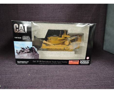 A Norscot 1:50 scale diecast, CAT D11R Carrydozer Track Type Tractor in yellow, in polystyrene packaging and in window displa