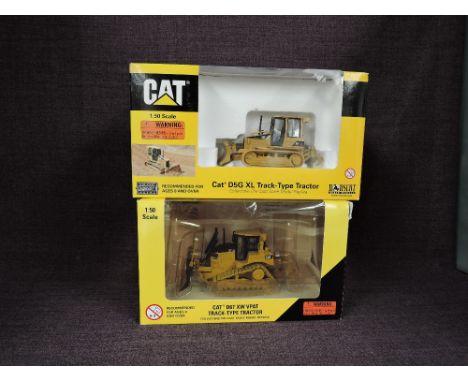 Two Norscot 1:50 scale diecasts, CAT D6T XW VPat Track Type Tractor in yellow, in plastic packaging and in window display box