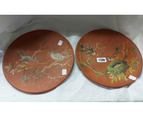 A pair of Longpark Torquay terracotta plaques with hand painted decoration, depicting nesting birds