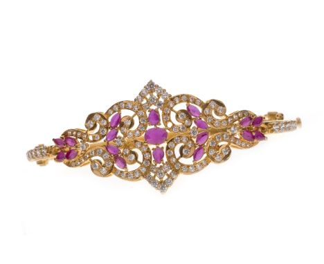 GEM SET BANGLE, of oval form and with a central openwork section set with white and red gems, 61mm to outer edge, unmarked, 1