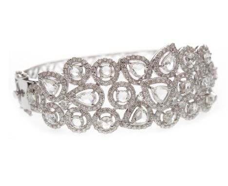 DIAMOND BANGLE, set with rose cut round and pear cut diamonds within round brilliant cut diamond halos, the diamonds totallin