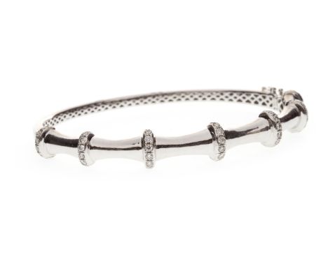 DIAMOND SET BAMBOO EFFECT BANGLE, of oval form, with diamond set bars interspaced by tapered blank sections, 64mm wide, marke