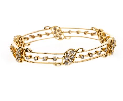 DIAMOND BANGLE, openwork, with S scroll sections set with round diamonds interspaced by narrow gold bars also set with diamon