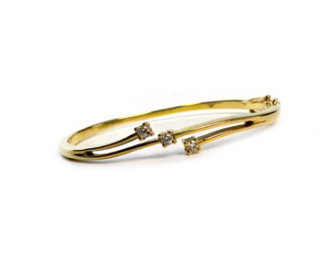 DIAMOND BANGLE, of oval form, the central section formed by three curving bars, two with a diamond terminal, one with central