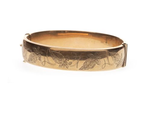 NINE CARAT GOLD BANGLE, with floral decoration to the exterior, with safety chain, 17.5g