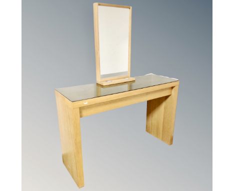 A contemporary glass topped vanity table fitted a drawer with light up mirror 