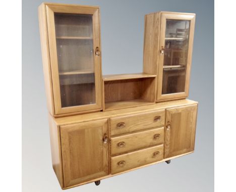 An Ercol Windsor elm and beech double door sideboard fitted with three central drawers 